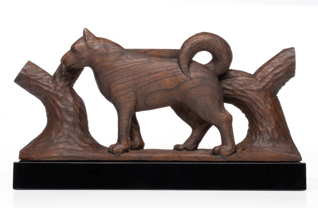A JAPANESE CARVED KEYAKI WOOD SIGN OF THE ZODIAC: The unsigned, hand carved figure of a dog, one of the twelve animals of the Japanese zodiac, is displayed on a finely lacquered stand and accompanied by a fitted paulownia wood tomobako. Measures 9.5 