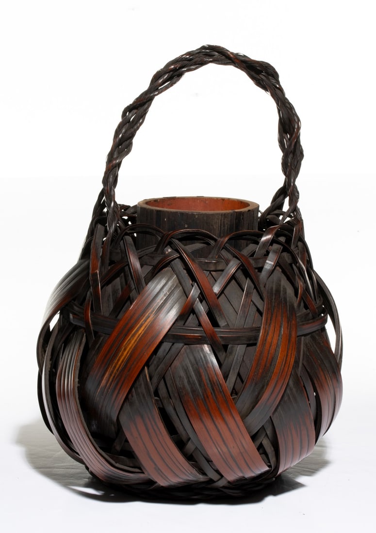 A JAPANESE WIDE SPLINT BASKET W/ LINER, ADAIR ESTATE: The bold and expressive example is dominated by wide, curved bamboo splints blending to a looping weave of narrower splints interlocked within a complex random-weave joining a thick, tightly twisted b