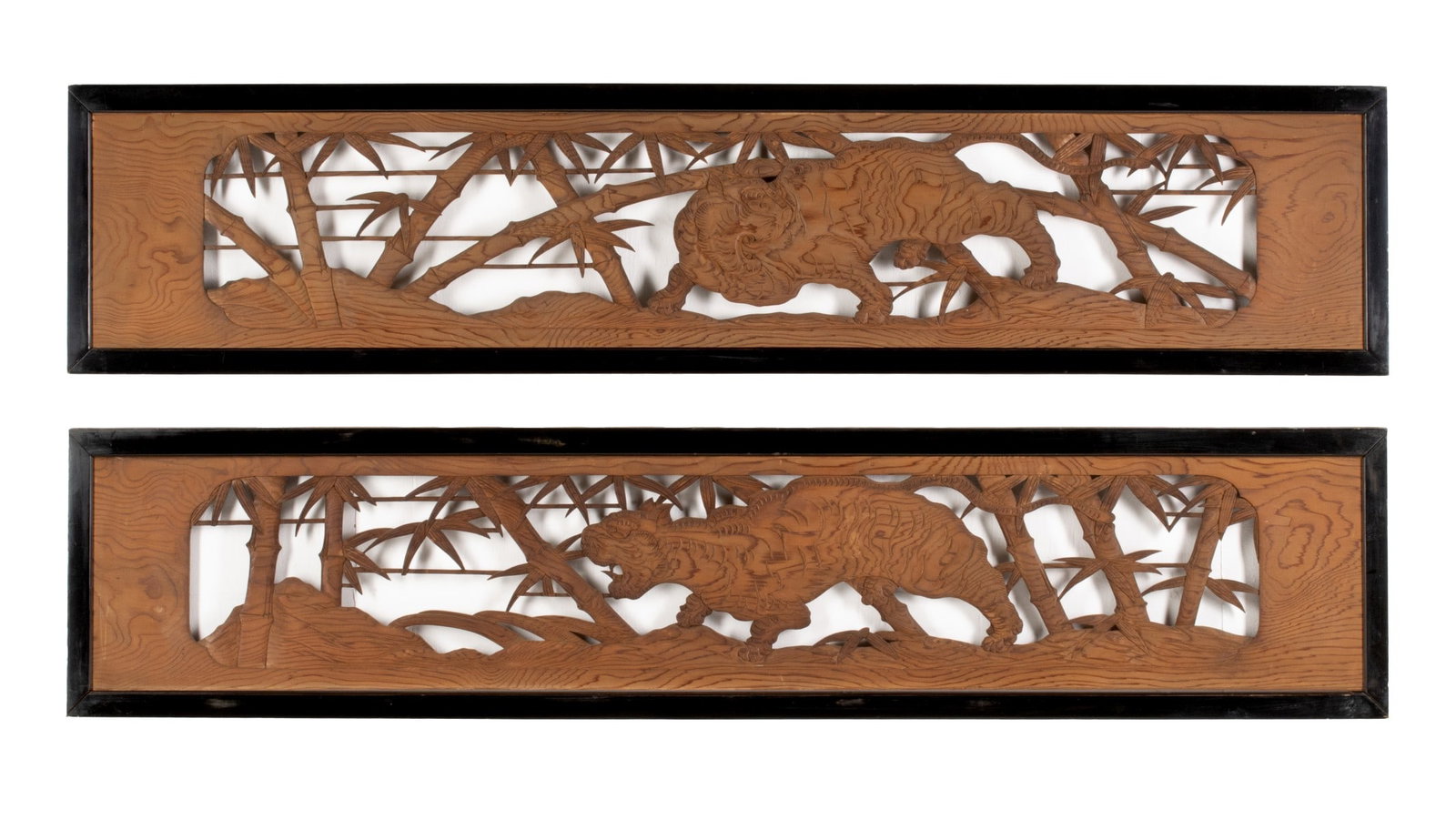 A PAIR OF CARVED CEDAR JAPANESE TRANSOM PANELS: A pair of solid cedar transom panels carved from cedar depicting tigers in a bamboo grove. Each measures 16 x 72.5 inches. Provenance: The estate of John Adair Jr. (1942-2025), founder and proprietor 