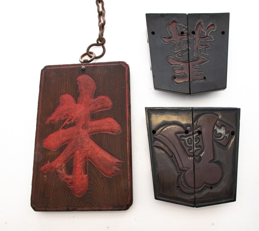 THREE JAPANESE RELIEF CARVED SHOPKEEPER'S SIGNS: The pair measures 9.5 x 9 and the sign is 15.5 x 10 inches without the chain. Provenance: The estate of John Adair Jr. (1942-2025), founder and proprietor of Kurofune Antiques in Tokyo (est. 1978), a 