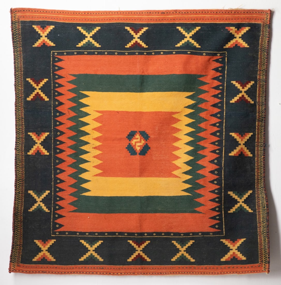A MODERN TURKISH KILIM, CENTRAL TURKIYE: The dark outer main border is decorated with a series of distinct stepped 'X'-form or hourglass motifs while the central field is anchored by a small, isolated central diamond lozenge containing a
