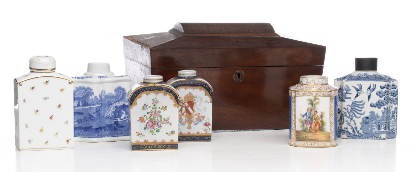 A COLLECTION OF 19TH CENTURY TEA CADDIES: American and other examples. The wood sarcophagus form example with flint glass insert has a broken foot with pieces inside the caddy. Sizes range from 4 x 3 x 3 to 7 x 12 x 6 inches. Provenance: The 