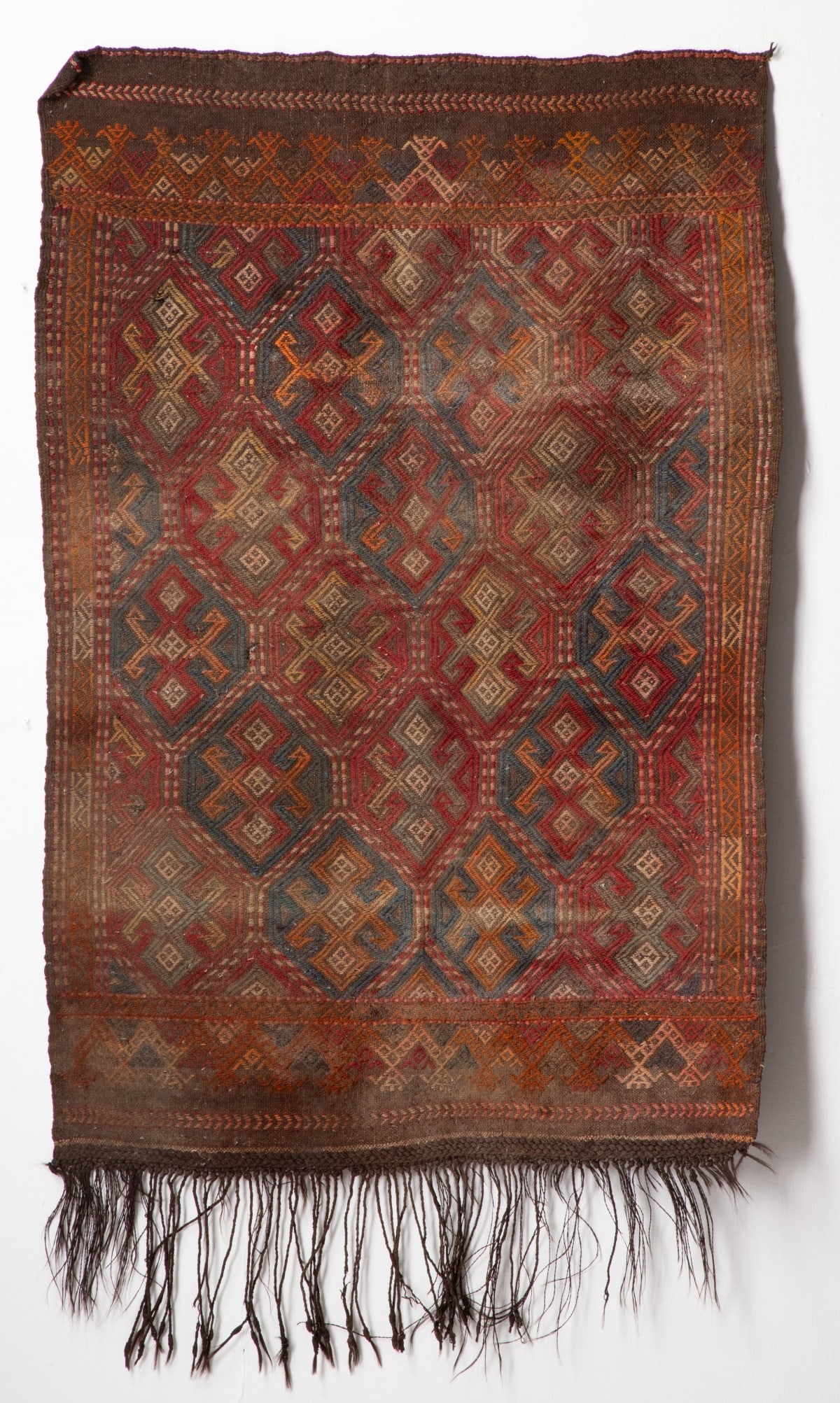 EARLY 20C. SOUTH CAUCASIAN, VERNEH FLATWEAVE AS FOUND: The hexagonal blue and red panelled field enclosing rows of offset tri rhombus medallions , between red and walnut turret horizontal end bands. Considerable mothing throughout. This rug has been store