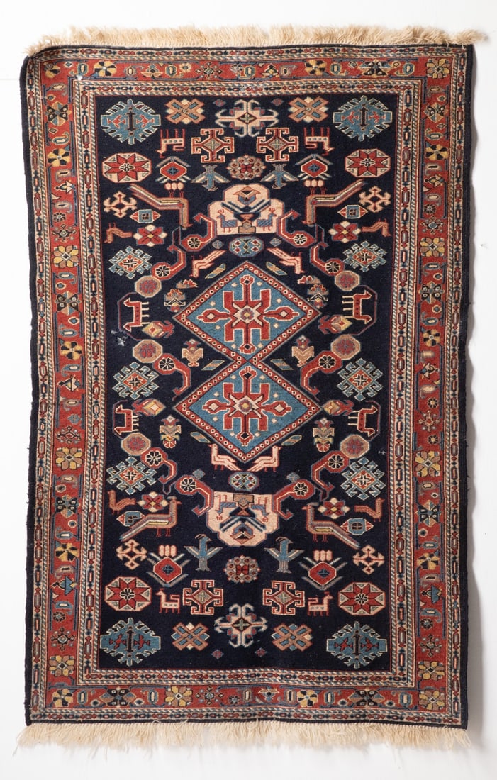 SOUTH WEST PERSIAN SOUMAK, LATE 20TH C. WITH DAMAGE: The blue field with two pale blue rhombus medallions supported by scattered animals, birds and flora forms, within a red continuous flower head border. Considerable mothing to the pile throughout. Thi