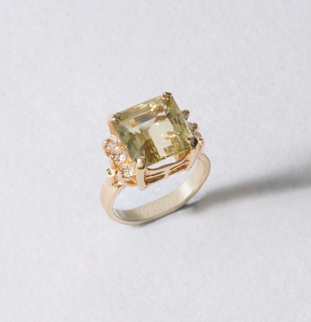 A LADIES 14K GOLDEN BERYL AND DIAMOND COCKTAIL RING: The golden beryl (a.k.a. heliodore) gemstone is set in a basket mounting with six side diamonds measuring approximately 0.06 carats each. Ring size of 5 with a total weight of 4.7 grams. Without
