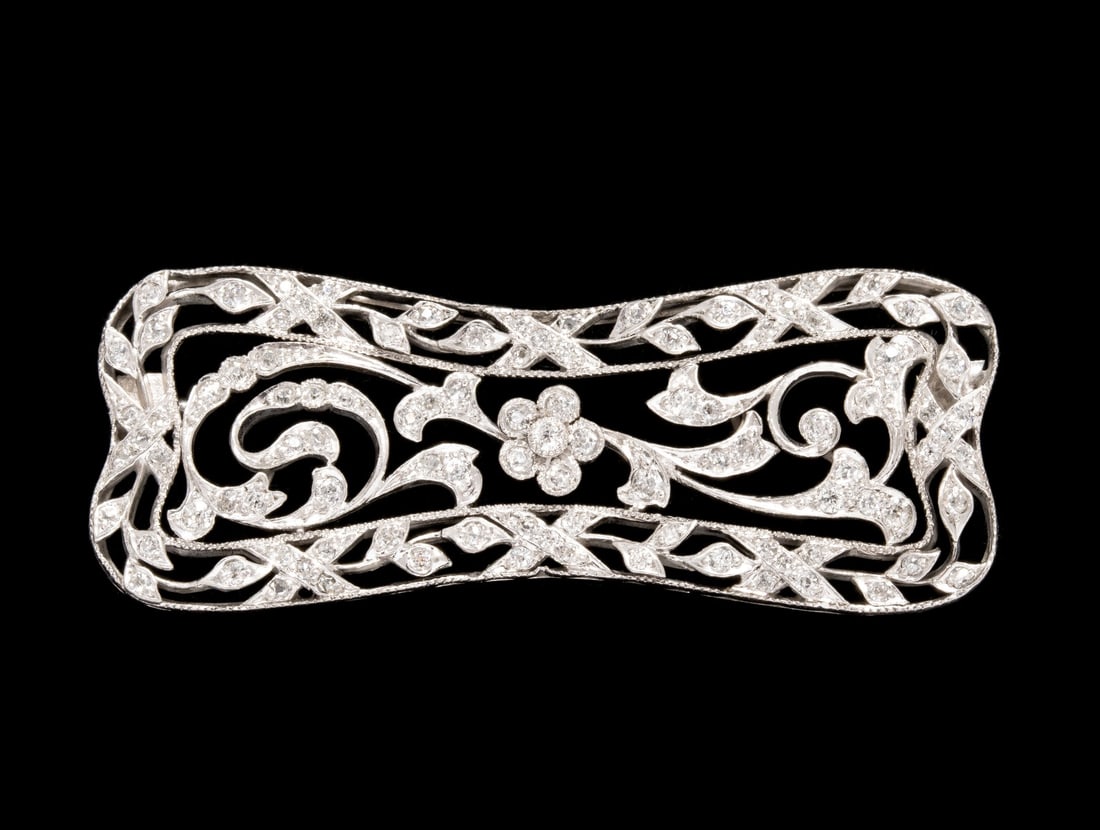 AN ART NOUVEAU ERA PLATINUM PIN WITH 108 DIAMONDS: The swirling openwork design in platinum is set with more than 100 nice, white old cut diamonds. Measures 0.75 x 2 and weighs 11 grams. Without proof of exemption, be aware that internet sales tax