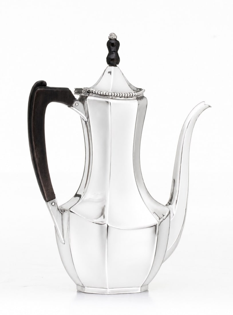 AN EARLY 20TH CENTURY STERLING SILVER DEMITASSE POT: The seven-sided form is mounted with an ebony handle (repaired). The lead image is a simulation. This item has heavy tarnish. Measures 9.25 x 7 x 3.5 inches and weighs 10.85 ozt. Without proof of
