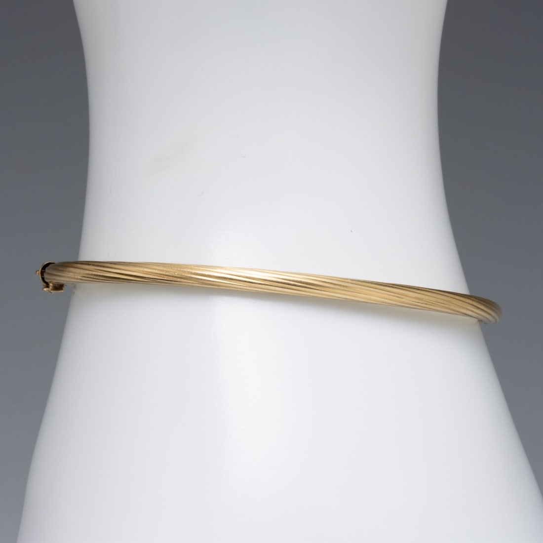 A VINTAGE ITALIAN 14K GOLD TWISTED RIB LADIES BANGLE: Marked 14kt inside near the clasp. Bracelet size is 6.5 with a total weight of 5.1 grams. Without proof of exemption, be aware that internet sales tax applies to all Internet transactions and local