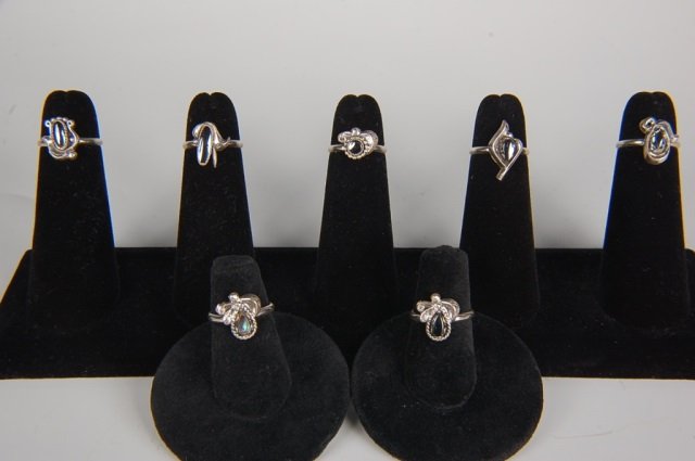 SEVEN HEMATITE OR ABALONE RINGS BY BELL, SIZE 4: Six with hematite cabochons and one with abalone, unsigned. Ring size 4. Designs measure from .325 to .625 inches.