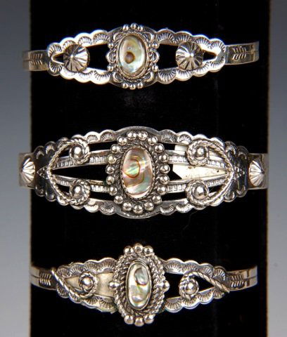 THREE STERLING & ABALONE CUFF BRACELETS BY BELL: Three chased sterling bracelets with polished abalone cabochons, all signed Bell and marked Sterling. Measure 6.75 x 1, 6.25 x 6.25 and 6.5 x .75 inches.