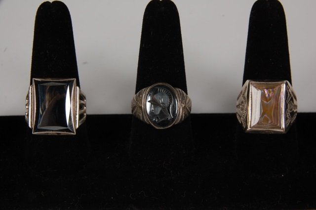 THREE ABALONE & HEMATITE STERLING MEN'S RINGS: A faceted hematite ring in a sterling setting, unmarked. Another hematite ring with a Roman warrior intaglio design, signed with the Bell Trading Post logo and marked sterling. Plus an abalone ring in