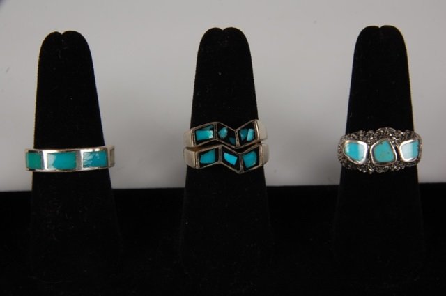 FOUR TURQUOISE & STERLING RINGS BY BELL: Inlaid turquoise gem stones in sterling silver settings, two are signed with the Bell Trading Post logo and marked sterling, the zig zag design rings are unmarked. Size 9. The two zig zag rings stack 