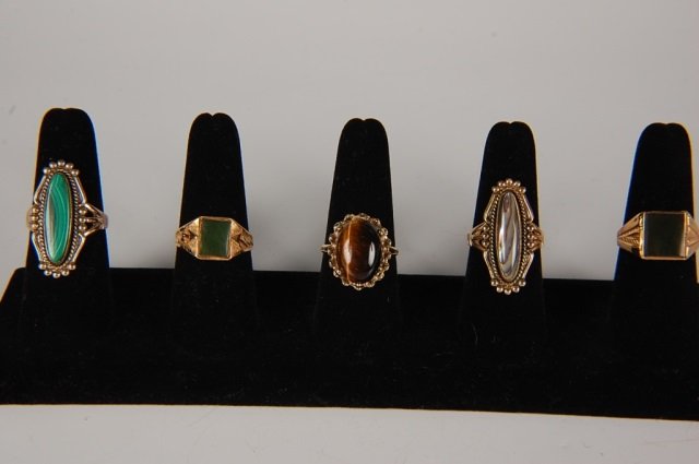 FIVE SEMI PRECIOUS RINGS BY BELL, SZ 8.5 TO 9: One abalone, one tiger eye, one malachite and two green jade semi precious stone rings. Abalone & malachite rings are signed with the Bell Trading Post logo and marked 12KT gold-filled; Tiger eye ring
