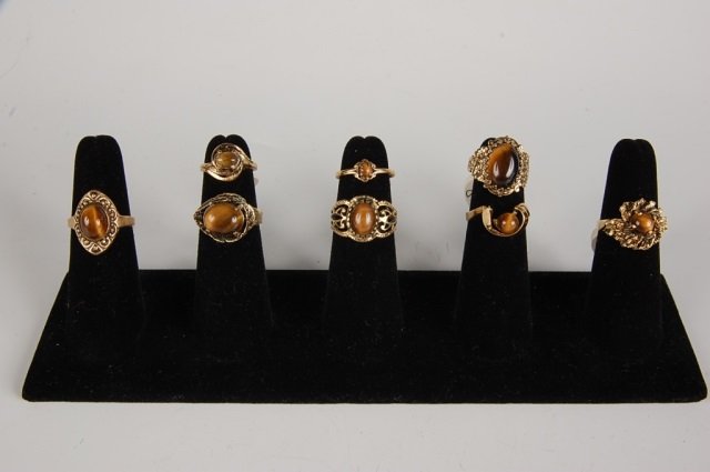 EIGHT TIGER EYE RINGS BY BELL, SZ 4 TO 7.5: Tiger eye rings, one is marked 18KT HGE for heavy gold electroplate, the rest are unmarked. Sizes 4 to 7.5.