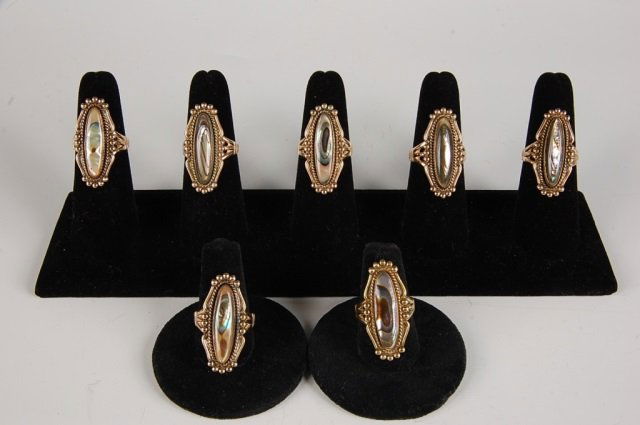 SEVEN ABALONE RINGS BY BELL, SZ 6.5 to 7.5: Seven abalone rings in gold-filled settings, marked 12KT GF and signed with the Bell Trading Post logo. Sizes 6.5 to 7.5.