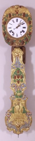 19TH C. FRENCH MOBIER BRASS WAG-ON-THE-WALL CLOCK: An ornate embossed and polychrome brass frame around the porcelain enamel dial, matching embossed brass pendulum also with the unusual painted decoration. Clock measures 16.75 x 12.5 x 7.25 inches wit
