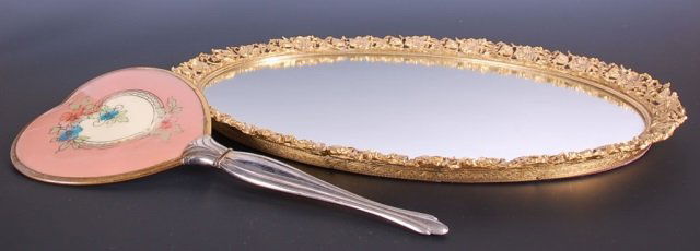DRESSER MIRROR: Along with a vintage hand mirror. Mirror measures 17 x 12 inches and hand mirror measures 13 x 5.5 inches.