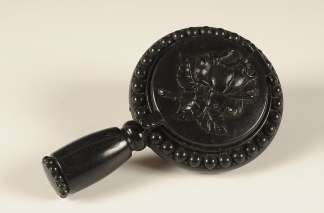 1940s PLATÉ TRIO-ETTE HAND MIRROR VANITY CASE: Hinged outer mirror over a rouge well with pan and puff, other side holds a inside mirror and powder well, no pan or puff, lipstick in handle, in black plastic, measures 4.5 x 2.75 inches.