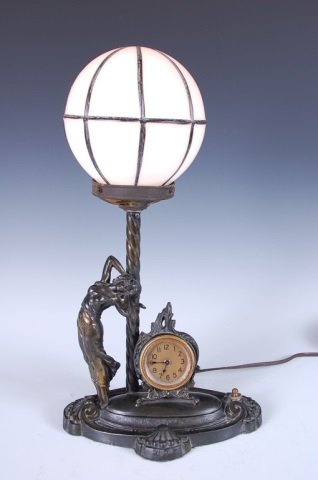 1920S FIGURAL LAMP WITH CLOCK: On a 9 inch long base set with a spring drive clock and figural maiden, overall measurements 17 inches high.