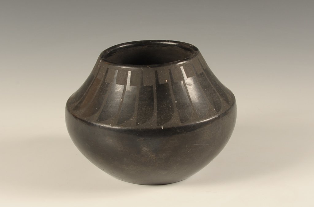 DESIDERIA SAN ILDEFONSO POTTERY: Black on black vase with repeating feather design, signed under the vase. Measures 5.5 x 6.5 inches.