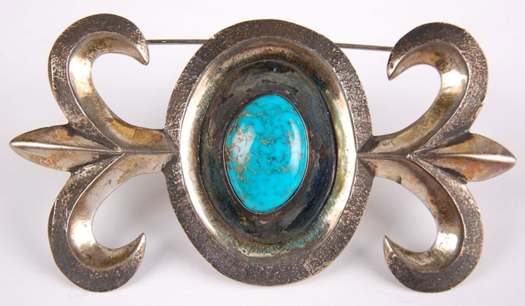 LARGE NAVAJO STERLING SAND CAST PIN WITH TURQUOISE: A handsome sand cast pin with central turquoise measures 2 x 3.75 inches. Unsigned.
