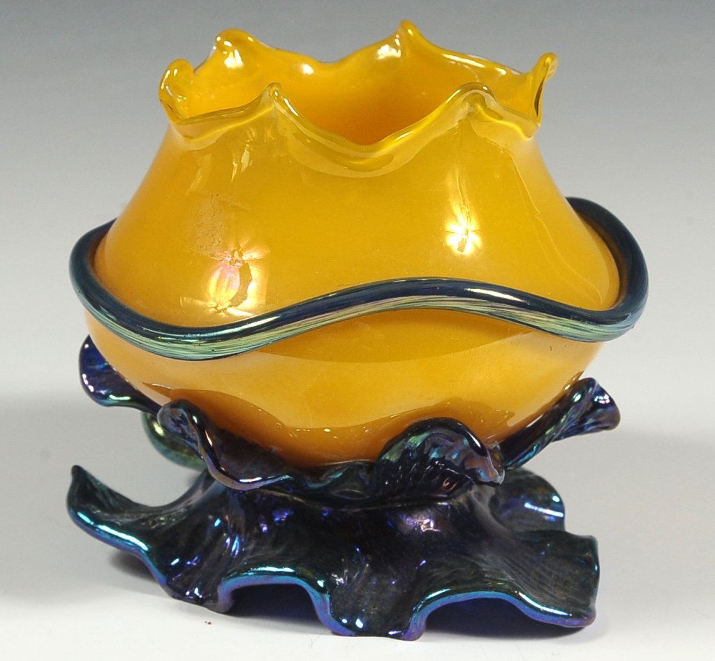 LOETZ CZECHOSLOVAKIA TULIP BLOSSOM VASE: A free form yellow tulip blossom aith applied irridescent blue glass tendrils and leaf shape base. A polished pontil under the base with oval Czechoslovakia acid etched mark. Measures approximately 4.