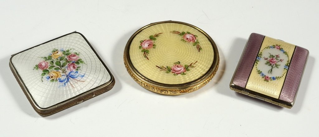 THREE GUILLOCHE ENAMEL COMPACTS: Three nice examples with hand painted florals on enamel. Sizes range from 2.75 inches in diameter, down to 2.25 x 1.75 inches.