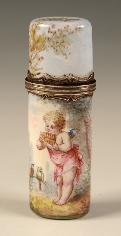 VIENNESE ENAMEL AND SILVER SCENT BOTTLE WITH CHERUB: A flat oval bottle with all-over enamel decoration of scene of cherub pan playing music for birds in a wooded landscape. Circa late 19th century. Measures 2.25 x .5 inches in diameter