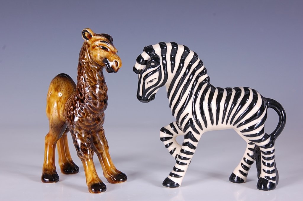CERAMIC ARTS STUDIO YOUNG CAMEL & ZEBRA FIGURES: Young camel in tan, measures 5.625 inches. Zebra in black and white measures 5.5 inches.