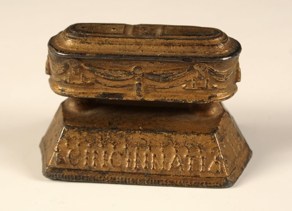 CIRCA 1880S CINCINNATI COFFIN CO ADVTG PAPERWEIGHT: Embossed markings and date along with the drape and style of the period, cast lead. Measures 1.75 x 2.75 x 1.75 inches.