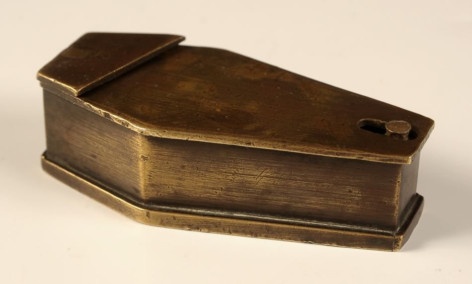 MINIATURE BRONZE MODEL OF A 19TH CENTURY COFFIN: The hinged lid pivots and reveals an open interior. Measures 1 x 3 x 1.5 inches.