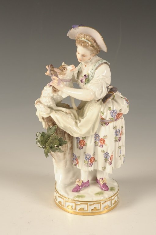 19TH C. MEISSEN PORCELAIN FIGURE OF MAIDEN AND DOG: With blue crossed swords mark under the base, a woman in 18th c. dress tying a lavender bow around a dog's neck. Measures 7 x 3.75 inches.