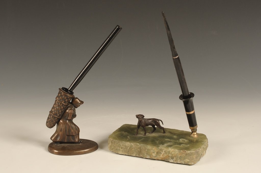 TWO FIGURAL PEN HOLDERS: Including a bird dog on a onyx base and figural bronze woman with bird and basket. Larger piece with dog measures 4 x 6 x 3.5 inches and the other figural piece measures 4.25 x 3 x 2.5 inches.