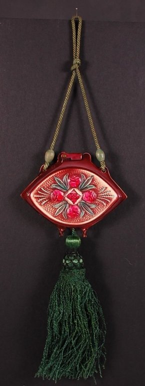 BAKELITE COMPACT WITH ROSES: With corded handle and large tassel, mirror in the lid and round powder well with puff, unmarked, measures 3.5 x 4.5 inches, measures 15.5 from handle to tassel.