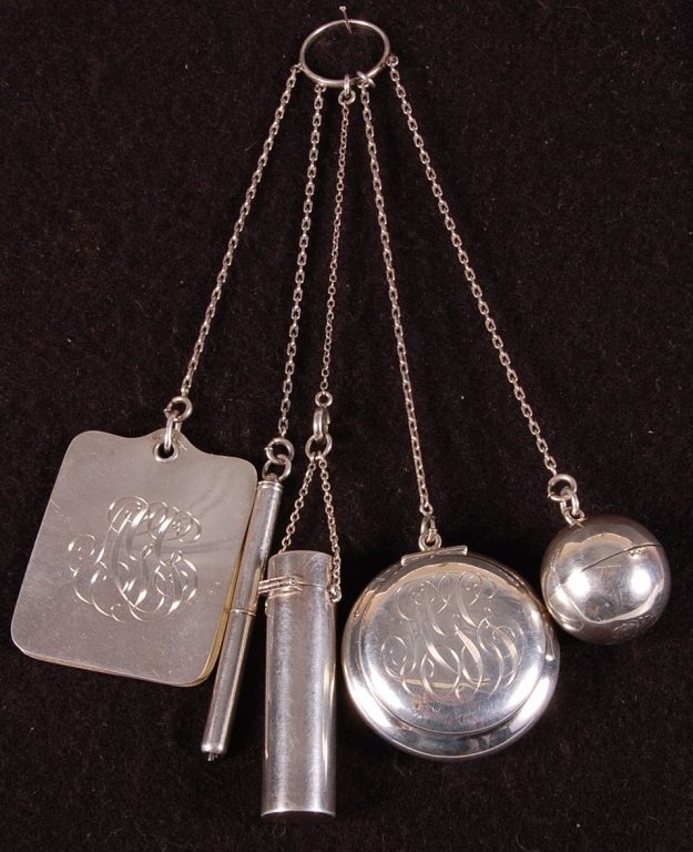 STERLING CHATELAINE ON A FINGER RING: With a compact, ball-shaped change holder for nickels, lipstick, pencil and notepad, marked sterling on the notepad and change holder, measures 7.75 inches, weighs 3.15 ozt.
