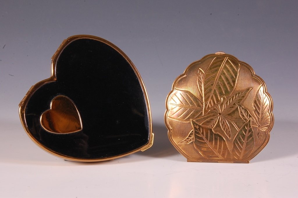 AMERICAN BEAUTY & REX FIFTH AVE. HEART COMPACTS: Stylized heart-shaped embossed goldtone compact by American Beauty, framed mirror in the lid, hinged powder well with branded puff, marked on the powder lid, measures 3 x 2.75 inches, very good. Goldt