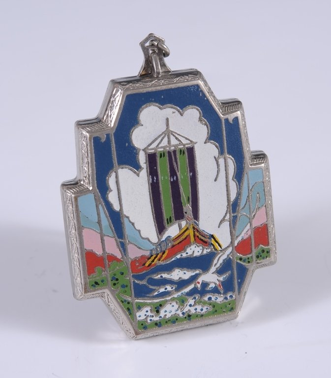 VANTIY CASE WITH A VIKING SHIP SCENE: Enameled vanity case on silvertone with a Viking ship scene on the lid, chain handle with a finger ring, framed mirror and rouge well in the lid with pan and puff, lipstick in its holder and powder we