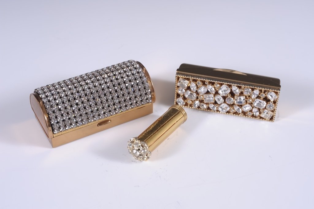 CRYSTAL COVERED BOLSTER MINIAUDIERE & LIPSTICK CASE: Crystal covered miniaudiÃ¨re bolster with a hinged mirrored lid over a cigarette compartment, hinged powder well with puff, another hinged well, unmarked, measures 3.75 x 2 inches. Plus a crystal je