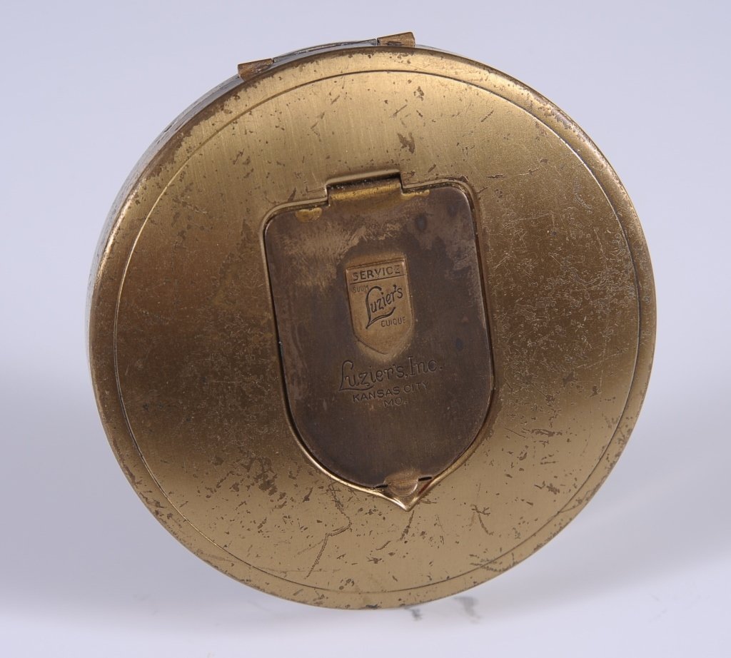 LUZIER'S COSMETICS, KANSAS CITY DUO COMPACT: Goldtone compact with silvertone base, hinged rouge well on top marked 'Luzier's Inc. Kansas City, Mo.,' mirror in the lid, hinged powder well in the base, measures 3 inches.