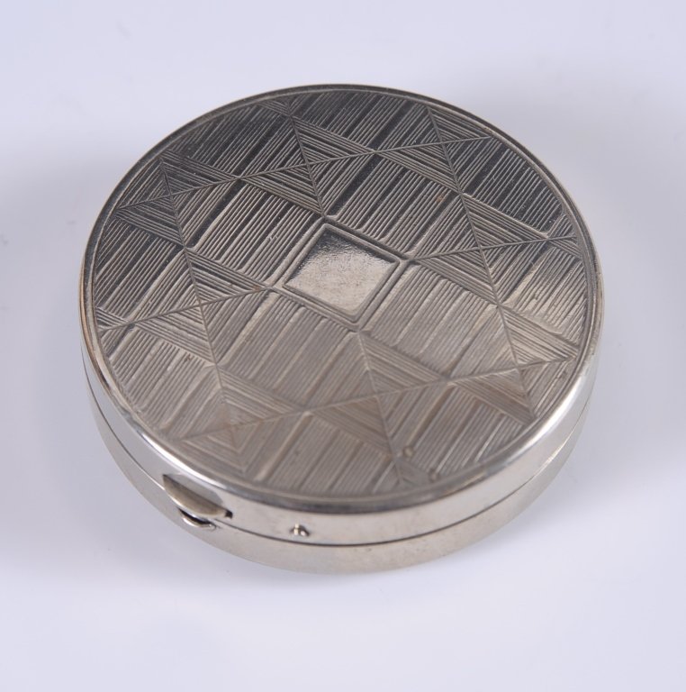 1926 AMAMI DUO COMPACT W INTERESTING HINGED MIRROR: Amami duo compact in silvertone with a rouge well with a pan in the lid, powder well in the base holds a mesh sifter and puff, unique hinged mirror swings out the side when the compact is opened, mark