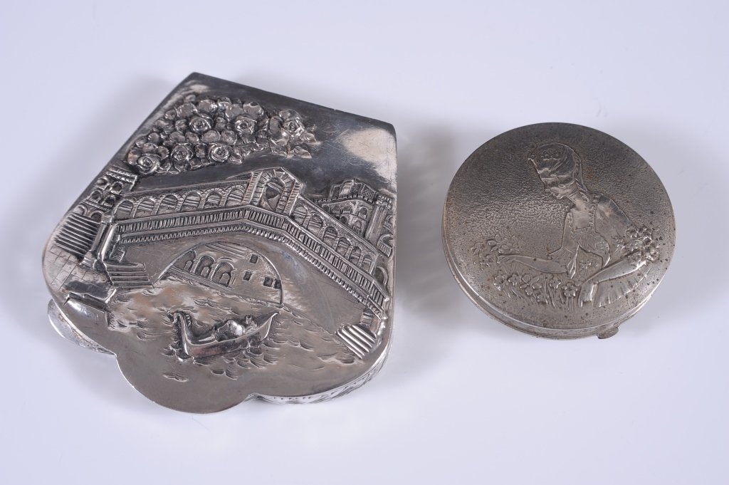 .800 COMPACT WITH EMBOSSED LID & A NORIDA COMPACT: .800 silver compact with an embossed scene of Venice on the lid, chased design on the base, framed mirror in the lid, marked on the clasp, measures 3.25 x 3.25 inches, very good. Plus a Norida compact
