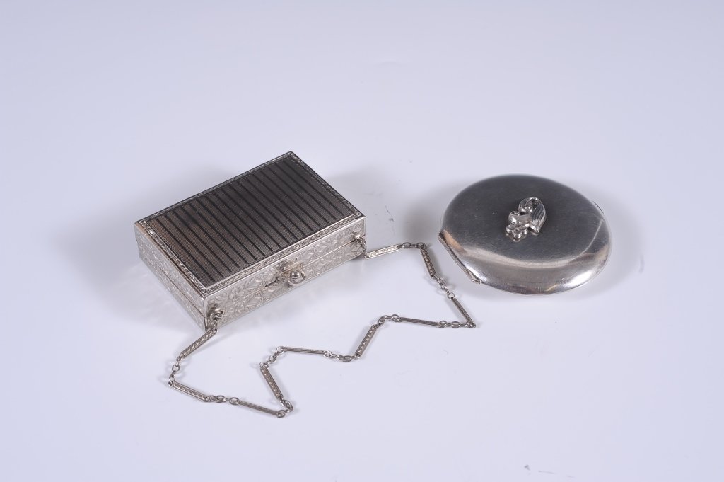 STERLING COMPACT, MINIAUDIERE W WOMAN WALKING DOGS: Sterling compact with a floral medallion on the lid, framed mirror in the lid, marked on the lip of the base, measures 2.75 inches, weighs 2.65 ozt., very good. Plus a miniaudiÃ¨re with a chain hand