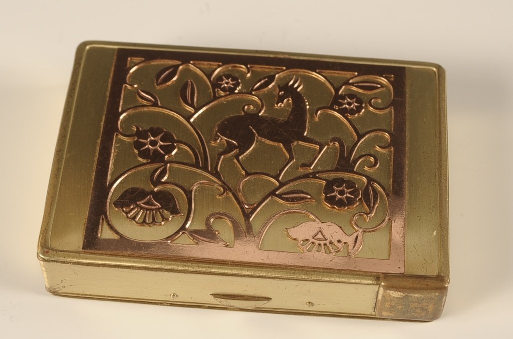 B.B. CO. MINIAUDIERE WITH FILIGREE ANTELOPE: Circa 1936 miniaudiere in brushed goldtone with a filigree antelope on top, lipstick release with a mirror in the lid, powder well with a mesh sifter and branded puff, other side holds a cigarette com