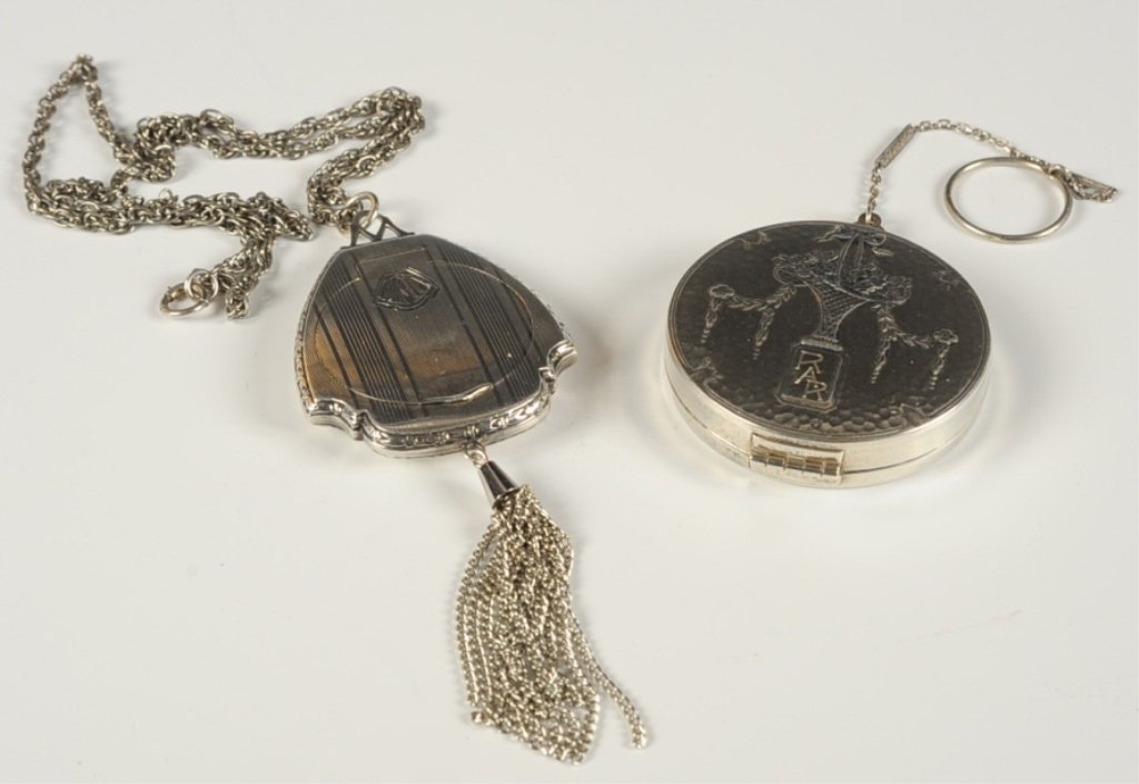 TWO STERLING COMPACTS ON CHAINS: The Thomae Co. sterling compact pendant with a tassel on a 16.75 inch chain, monogrammed 'MAW' on top, framed mirror in the lid, marked in the powder well, measures 2.5 x 1.75 inches, weighs 1.2 ozt. 
