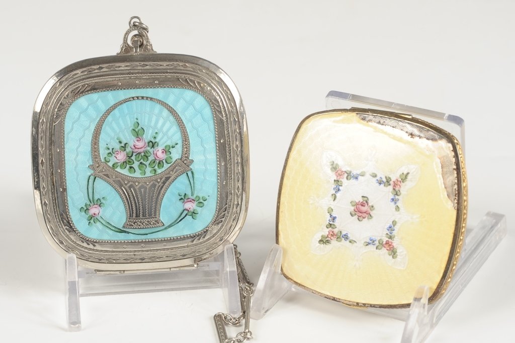 TWO GUILLOCHE COMPACTS: Blue guilloche with a floral basket on top, chain handle, framed mirror in the lid, unmarked, measures 2.5 x 2.5 inches with 6 inch handle, mirror has some silvering loss. And a La Mode yellow guilloc