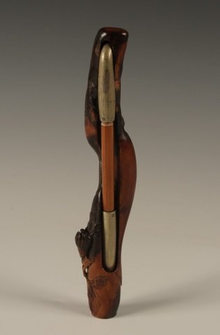 C. 1900 OPIUM PIPE IN SNAKE CARVED ROOTWOOD HOLDER: Carved wood holder with snakes and signature holds a bamboo and nickel opium pipe. Measures 8 inches long.