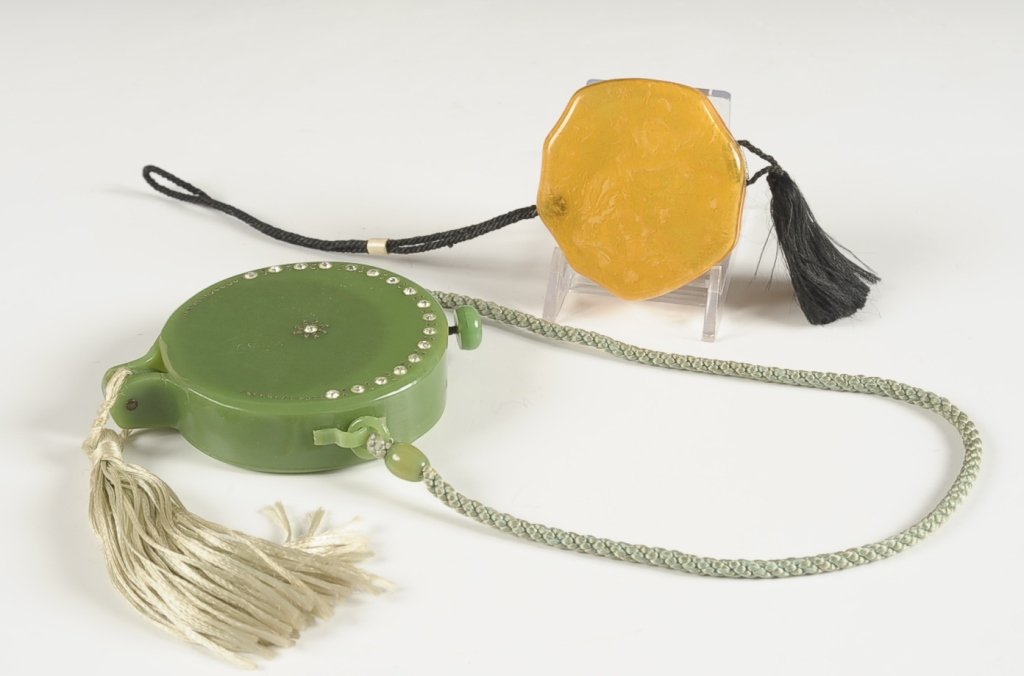 TWO VINTAGE PLASTIC VANITY CASES: Vintage green plastic vanity case with inset crystals, cord handle and tassel, beveled mirror in the base, lid holds a powder well with puff and a lipstick in a clip, measures 3.5 inches, 14.5 inches 