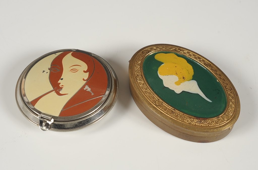 1926 HUDNUT ENAMELED COMPACT W WOMAN & ANOTHER: Richard Hudnut silvertone enameled compact with an Art Deco woman's face on the top, patent dated 1926, polished metal mirror over a rouge well in the lid with pan and puff, hinged powder well in the 