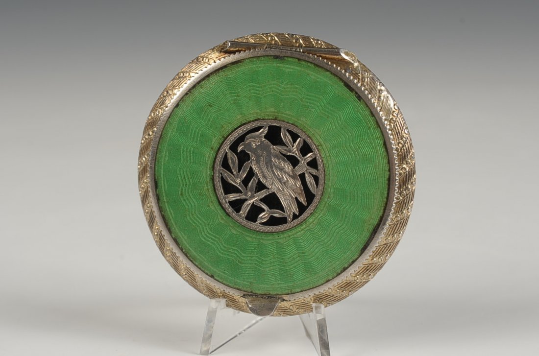 AUSTRIAN STERLING GUILLOCHE COMPACT: Green guilloche with a filigree bird on top, framed beveled mirror in the lid, rotary sifter in the base, marked on the mirror rim and inside the powder well, measures 2.125 inches, weighs 1.55 ozt.