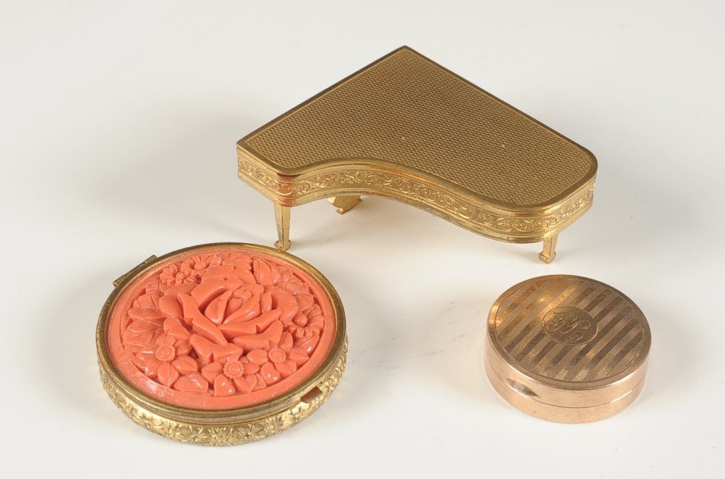FRENCH PIANO-SHAPED COMPACT, PLUS TWO MORE: Piano compact with folding legs, marked on the back leg, measures 2.75 x 2.5 inches. Goldtone duo compact with a faux coral top, measures 2.25 inches. And a D.Q. English compact, monogrammed on top, m